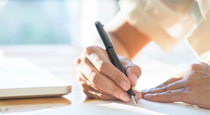 Frau beim Unterzeichnen eines Bauvertrags