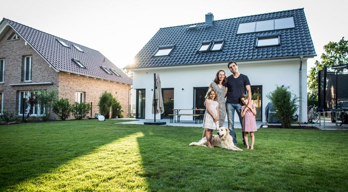 Baufamilie vor ihrem neuen Eigenheim