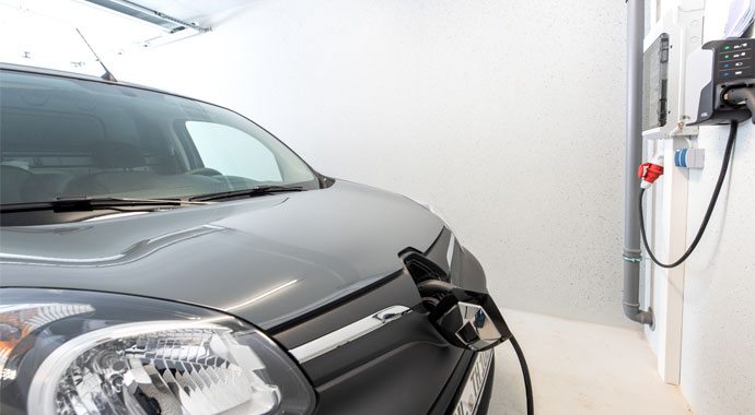 Parkendes E-Auto in einer Betonfertiggarage Parkendes E-Auto in einer Betonfertiggarage