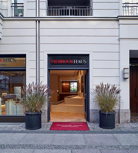 Aussenansicht des Eingangs vom Viebrockhaus Flagship Store in Berlin Charlottenburg mit Logo ueber der Tuer und zwei grossen Pflanzenkuebeln davor