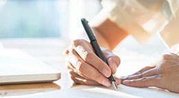 Frau beim Unterzeichnen eines Bauvertrags