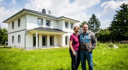 Bauherren vor ihrem neu errichteten Eigenheim