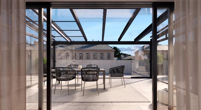 Innenansicht von einem geöffneten Glas-Schiebedach über einer modernen Penthouse-Terrasse mit Blick auf einen eleganten Essbereich und die umliegende Stadtarchitektur.